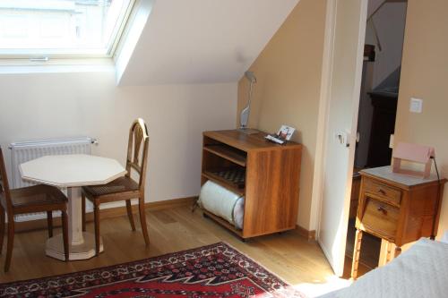 アミアンにあるLe Kiosque Amiens chambres d'hôtesのテーブル、テーブル、椅子が備わる小さな客室です。