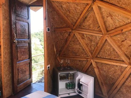 a small refrigerator in a room with a wooden wall at “Entres sueños”, el lugar ideal para soñar in La Calera