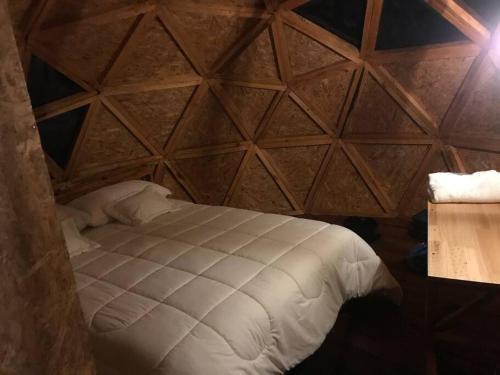 a bed in a room with a wooden wall at “Entres sueños”, el lugar ideal para soñar in La Calera
