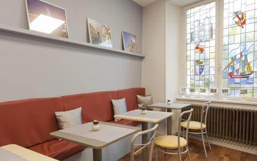 a restaurant with two tables and stained glass windows at Logis Hôtel Duquesne in Nantes