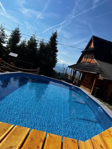 a large blue swimming pool next to a house at Domek w Górach- Bacówka u Dudka in Nowy Targ