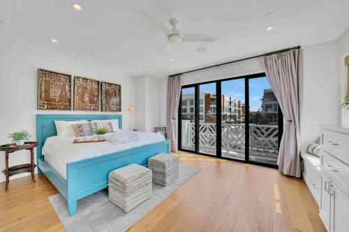 a bedroom with a blue bed and a large window at Coastal Paradise . Steps to the beach . Pool . Hot Tub in Huntington Beach