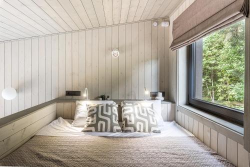a bed in a room with a window at NEILA - 'Virš Ąžuolų' - Forest SPA - FREE jacuzzi in Paplatelė
