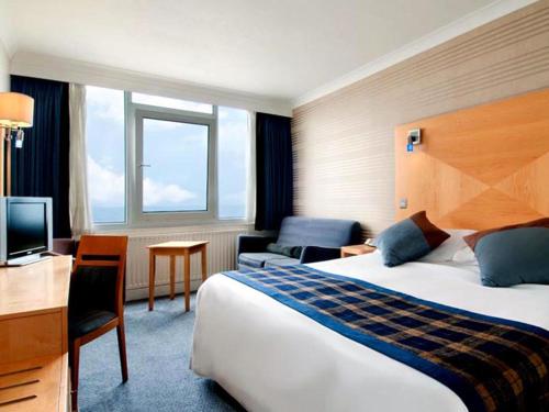 a hotel room with a bed and a desk at Best Western Palace Hotel & Casino in Douglas