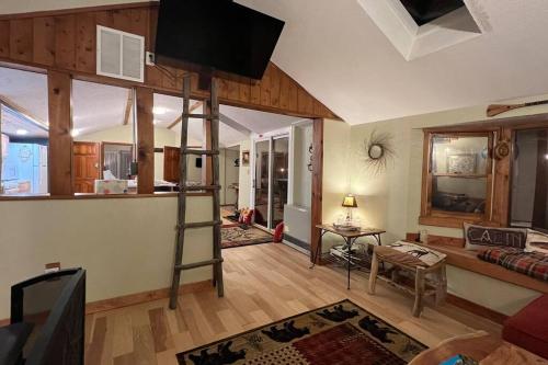 ein Wohnzimmer mit einer Leiter in der Mitte eines Raumes in der Unterkunft Thorpe On The Water. Creekside Nederland Cabin. in Nederland