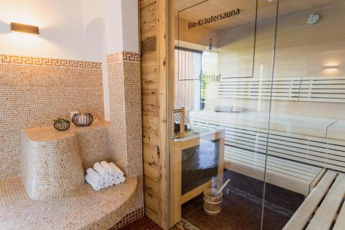 a bathroom with a shower with a glass door at Hotel Sperlhof in Windischgarsten