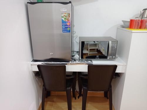 Biały stół z kuchenką mikrofalową i lodówką w obiekcie Departamento Mini 2 pers w mieście Tacna