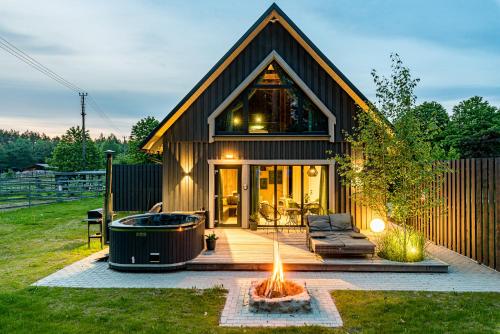 a house with a hot tub in the yard at SOPRANO - 'Virš Ąžuolų' - Forest SPA - FREE jacuzzi in Paplatelė