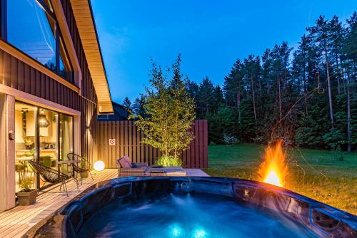 a hot tub in the backyard of a house at SOPRANO - 'Virš Ąžuolų' - Forest SPA - Horses - Lake in Paplatelė