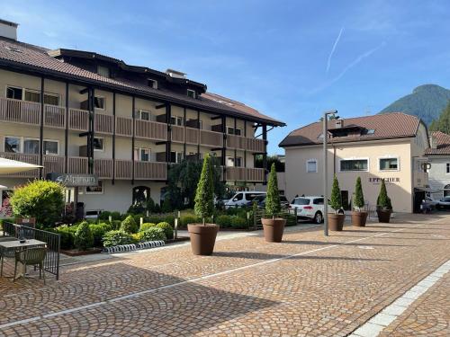 a courtyard with potted plants in front of a building at Residence Hotel Alpinum in Campo Tures