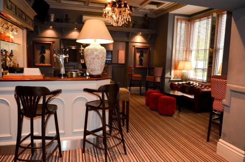 a bar in a living room with stools at Regent Hotel Doncaster in Doncaster