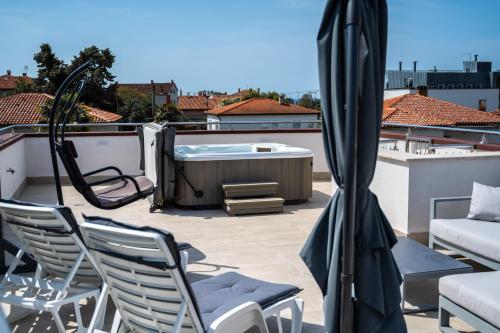 a patio with chairs and a hot tub on a roof at Villa Alpa in Umag