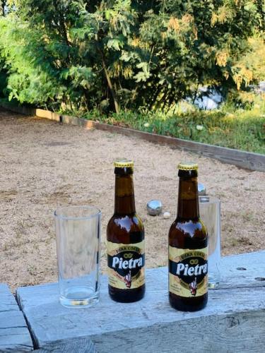 deux bouteilles de bière assises sur une table avec un verre dans l'établissement F2 avec jacuzzi, pétanque, à 3 min mer, dans grande propriété, à Porticcio