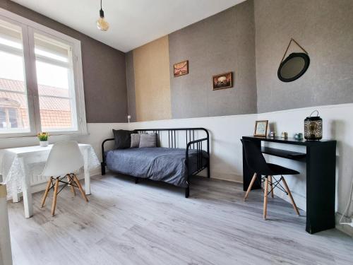 une chambre avec un lit, une table et un bureau dans l'établissement Studio du théâtre, à Saint-Omer