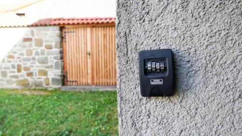 a remote control on the side of a stone wall at River loft in Ilirska Bistrica