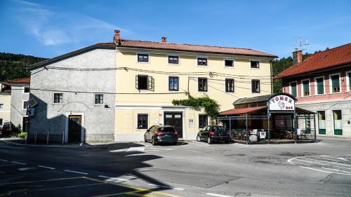 a building with cars parked in front of a street at River loft in Ilirska Bistrica