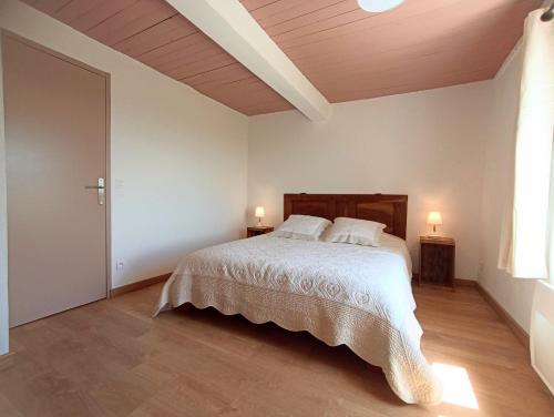 a white bedroom with a bed and two lamps at Gite avec piscine "La maison de Valentine" en Provence in Le Plan