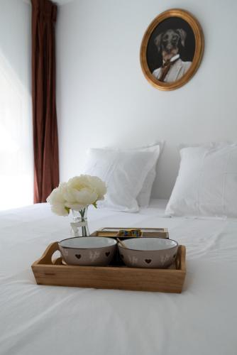 - un plateau avec 2 bols et un vase de fleurs sur un lit dans l'établissement LITTLE MAMA including a parking space at 100 meters, à Colmar