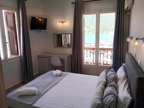 1 dormitorio con 1 cama blanca grande y ventana en GEORGIOS L, en Skopelos Town