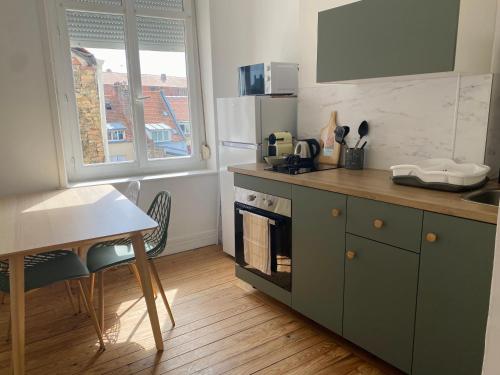 Il comprend une cuisine équipée d'une cuisinière, d'une table et d'un comptoir. dans l'établissement 1st Floor Cozy Central Flat with free parking, à Boulogne-sur-Mer