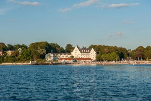 a view of a beach with people on the water at Strandhotel Glücksburg in Glücksburg