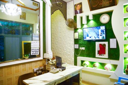 a bathroom with a sink and a mirror and a phone at New Taj Hotel in Lahore