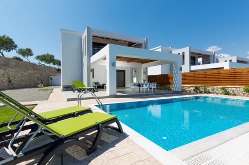 a villa with a swimming pool and a house at Antonoglou Beach Villas - Waterfront Luxury Retreat in Gennadi
