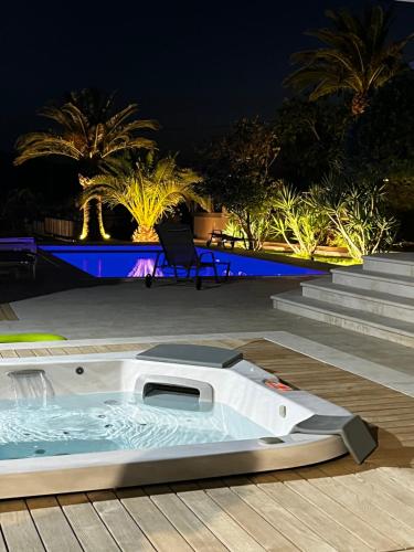 a hot tub on the deck of a resort at night at Villa Birk in Barbat na Rabu