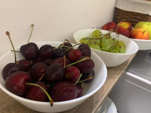 three bowls of cherries and apples on a counter at B&B D'Amari Affittacamere in Palermo