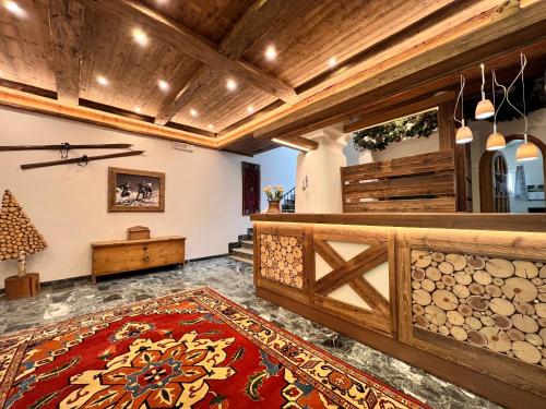 a room with a wooden fence and a red rug at B&B Garni Villa Campitello in Campitello di Fassa