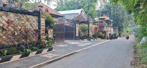 a person riding a motorcycle down a street with houses at Villa Jackson in Tejakula