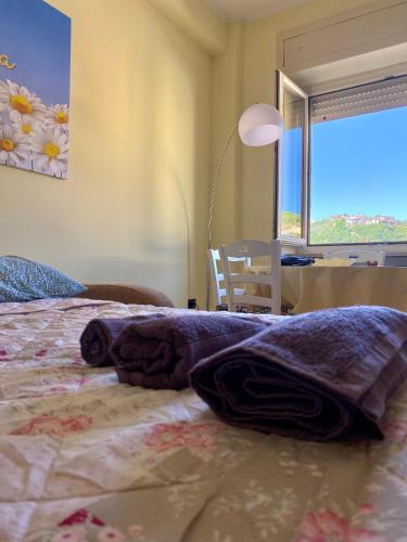 a bedroom with a bed and a desk and a window at La Divina in Cosenza
