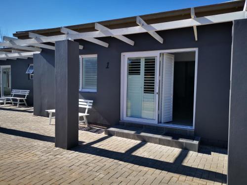 a blue house with a pergola on a patio at 10 Jock Meiring Guesthouse unit 1 in Bloemfontein