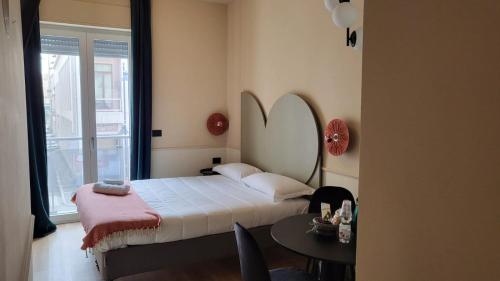 una camera con letto, tavolo e finestra di TUTTOTONDO a Pescara