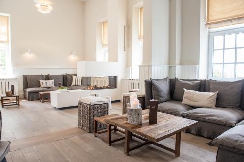 a living room with couches and a table at Strandhotel Glücksburg in Glücksburg