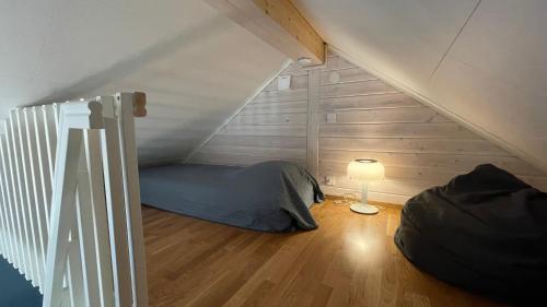 een kamer met een bed en een lamp op zolder bij Floda, Minihus på 62m2 för plats för 4 vuxna och 2 barn in Floda