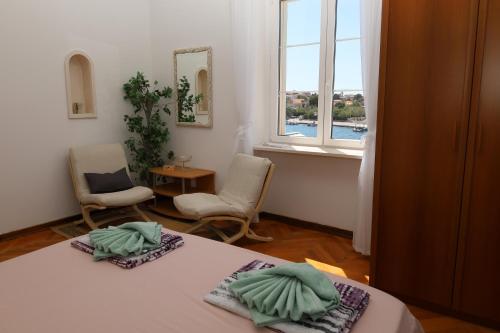 a room with a bed and two chairs and a window at Apartman DAJANA in Supetar