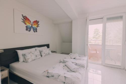 um quarto com uma cama com uma fotografia de borboleta na parede em VILLA EKATERINA em Ohrid