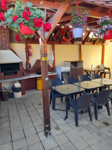 een patio met tafels en stoelen en bloemen in een gebouw bij Vila Marius-camere de închiriat in Eforie Nord