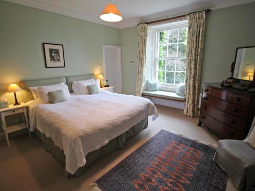 a bedroom with a large bed and a window at Viewfield House in Portree