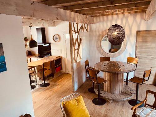 une pièce avec une table et des chaises et une cuisine dans l'établissement Logis La Reine des Sables, à Vaux-sur-Mer