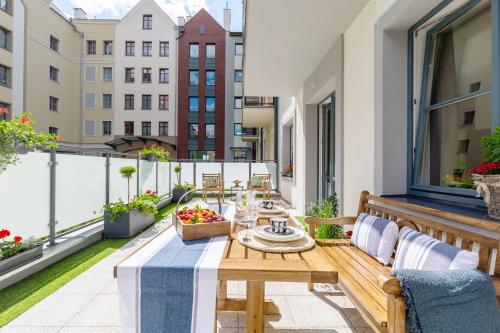 a balcony with a table and chairs on a roof at Bea Garden Home - dwie sypialnie i taras in Elblag