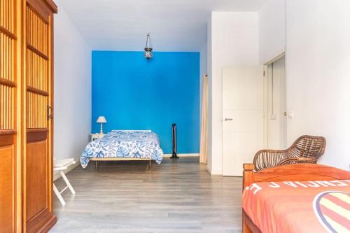 a room with a bed and a blue wall at 120 sqm Loft-style Apartment Beach Royal Marina in Valencia