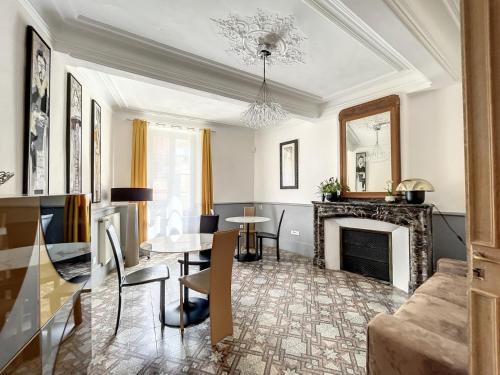 un soggiorno con tavolo e camino di L'Oiseau Bleu ROLLIER a Roubia