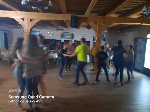 a group of people dancing in a room at Pensiunea Valea Branzei in Năneşti