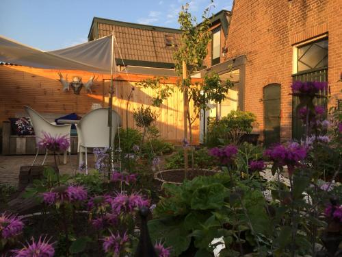 a garden with purple flowers in front of a building at Op Nijverdal in Nijverdal