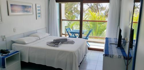 a room with a bed and a television and a window at Araça Flat Natal Prime - Beira Mar in Natal