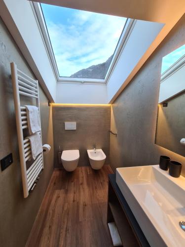 a bathroom with a skylight and a toilet and a sink at Chalet Gravina in Ortisei