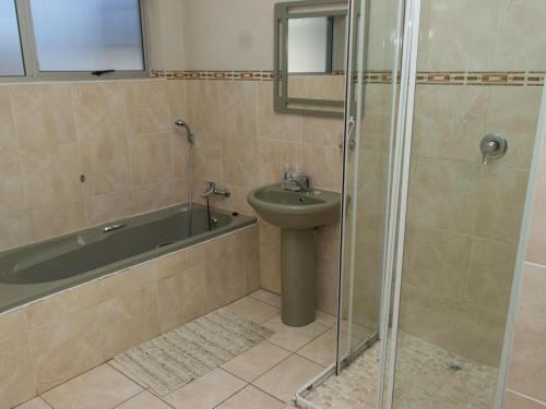 W łazience znajduje się prysznic, umywalka i wanna. w obiekcie Three Angelz Lodge w mieście Queenstown