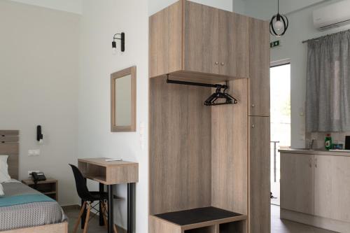 a bedroom with a bed and a wooden partition with a desk at Loggos Apartments in Lóngos